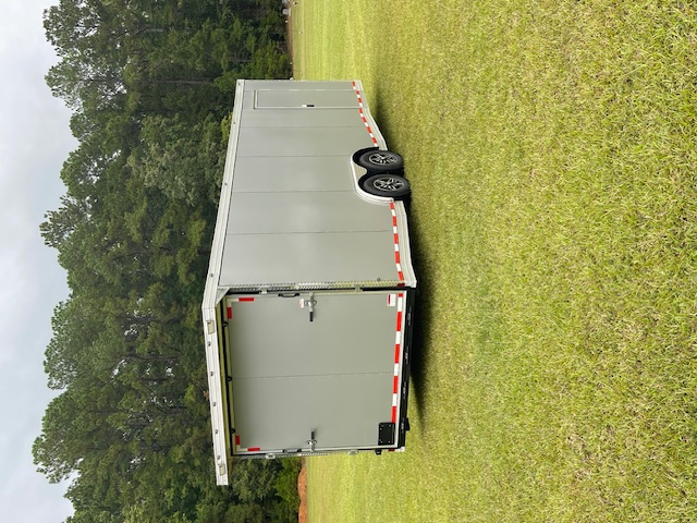 TraiGo 24 foot enclosed car hauler trailer parked in an open field